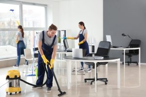 Nettoyeurs professionnels avec un homme et deux femmes qui nettoient les bureaux avec un équipement. Océanick Nettoyage à Québec.