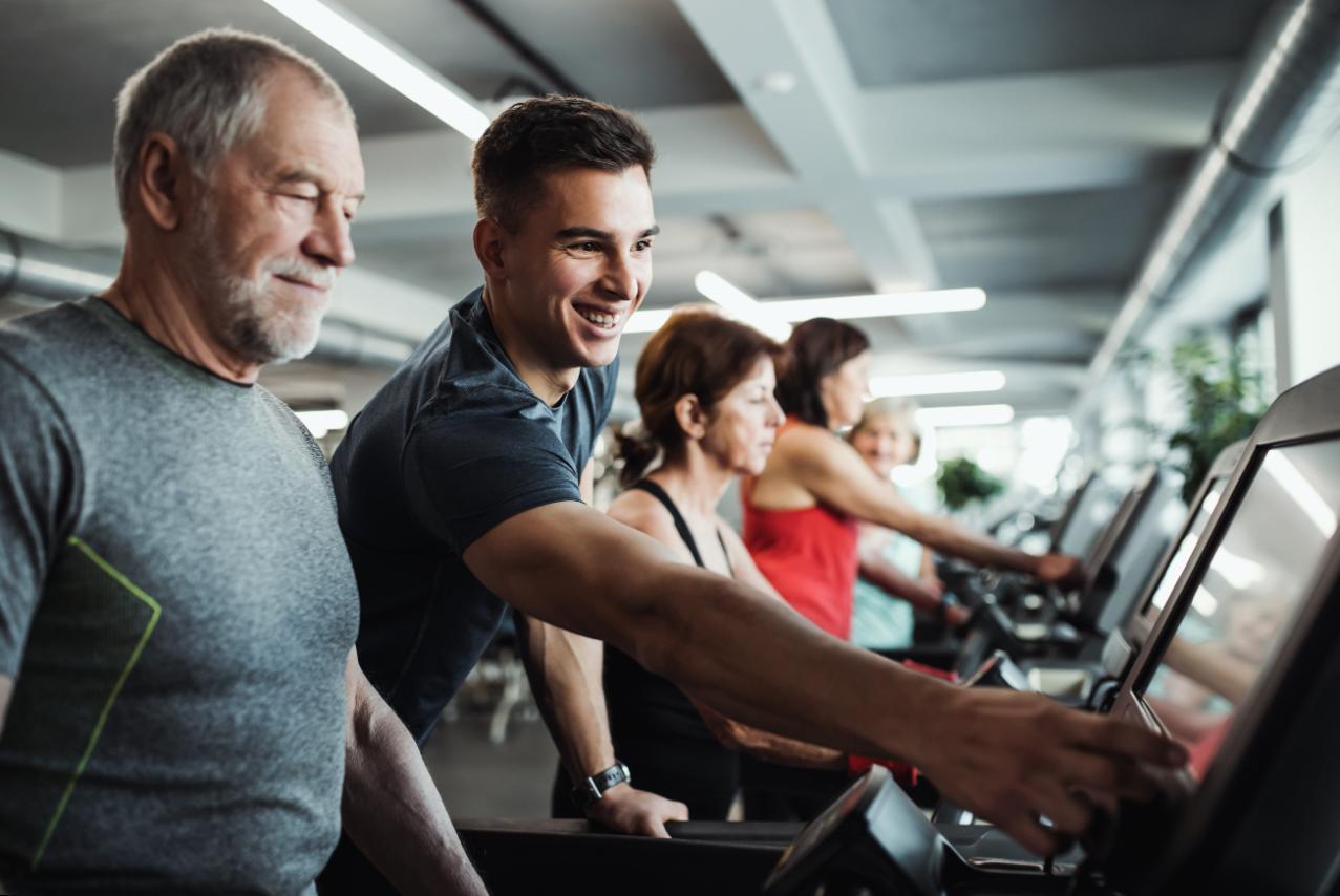 Coach expérimenté donnant des conseils sur le cardio et la santé sportive à un homme sénior. 